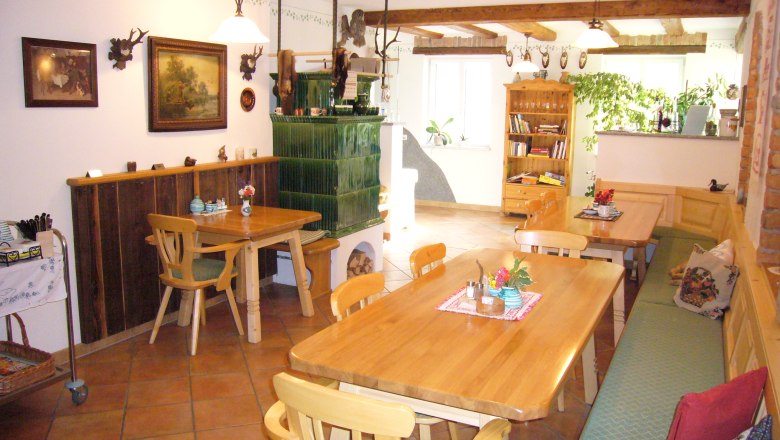 Mayrhof Haag, © zVg Gemütlicher Gastraum mit Holzmöbeln und Kachelofen.