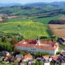 Benediktinerstift Seitenstetten, © www.stift-seitenstetten.at Luftaufnahme des Benediktinerstifts Seitenstetten umgeben von grünen Feldern und Hügeln.