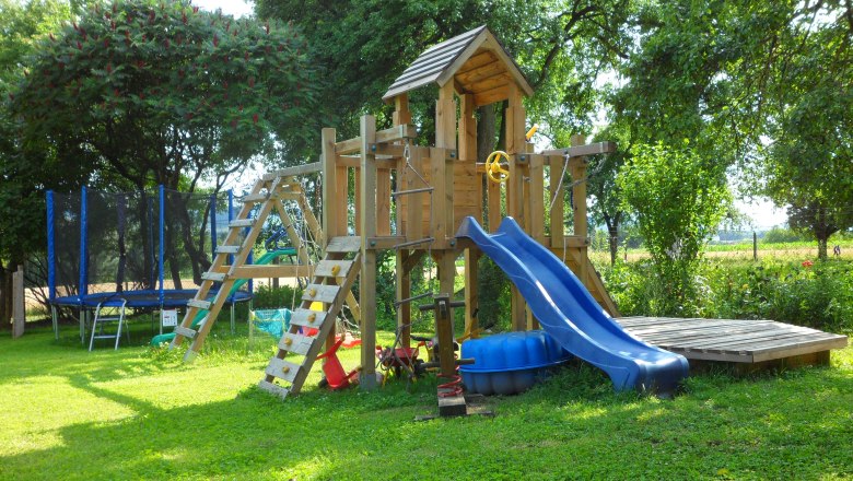 Garten mit Spielplatz, © zVg Gruber-Ellinger Ein Spielplatz im Garten mit Klettergerüst, Rutsche und Trampolin.
