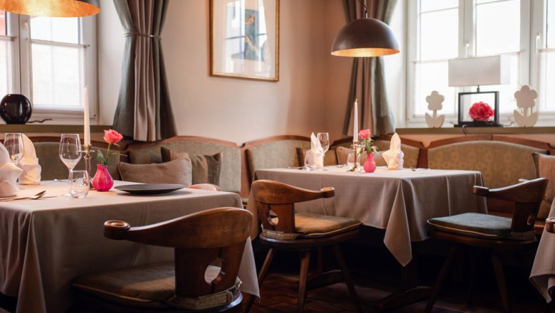 Gaststube in heimeligen Pastelltönen, © Niederösterreich Werbung/Daniela Führer Gemütliche Gaststube mit gedeckten Tischen, Kerzen und Blumen in Pastelltönen dekoriert.