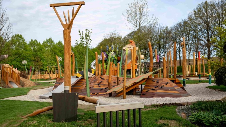 Erlebnisgarten Spielplatz, © starkl-diemosttirolerin Ein moderner Spielplatz mit Holzstrukturen und Kletterelementen in einem grünen Park.