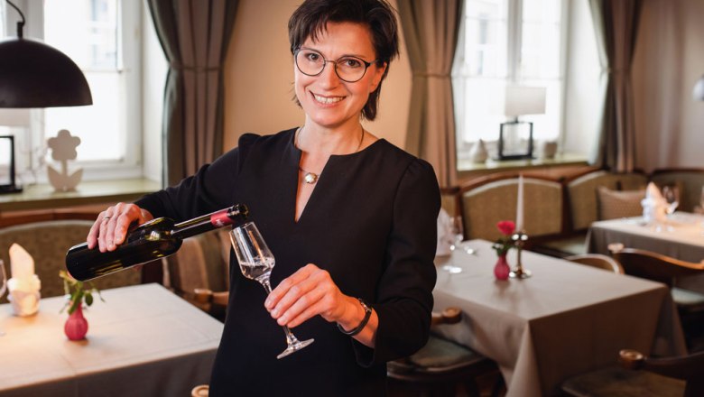 Perfektes Service und Gastlichkeit, © Niederösterreich Werbung/Daniela Führer Eine Frau in einem Restaurant schenkt Wein in ein Glas ein.