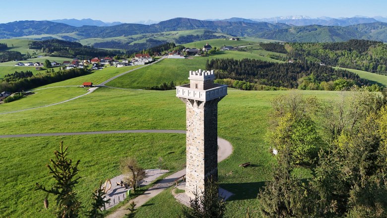 Aussichtsturm inmitten gr&uuml;ner H&uuml;gellandschaft.