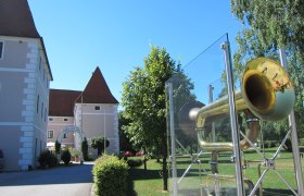 Schloss Zeillern mit einer großen Trompete im Vordergrund.