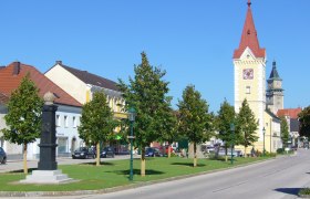 Stadtzentrum mit Turm und Schloss im Hintergrund.