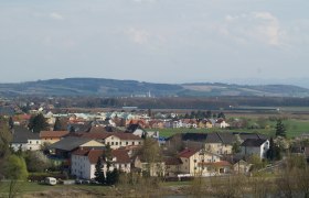 Panoramablick auf Ennsdorf mit H&auml;usern und H&uuml;geln im Hintergrund.