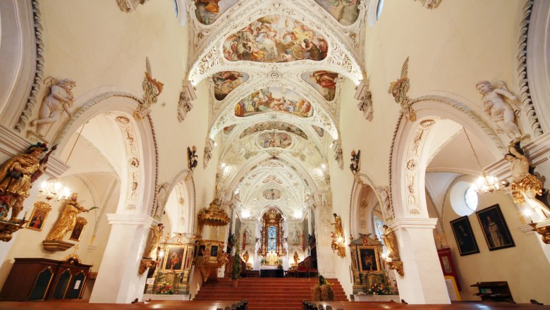Innenansicht der Stiftskirche Ardagger mit kunstvoll bemalter Decke und reich verzierten Wänden.