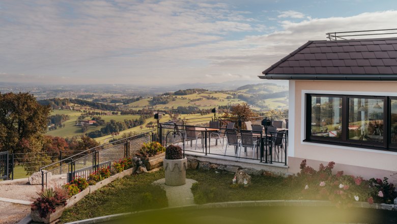 Panoramablick von einem Gasthof in St. Peter in der Au mit Terrasse und Landschaft.