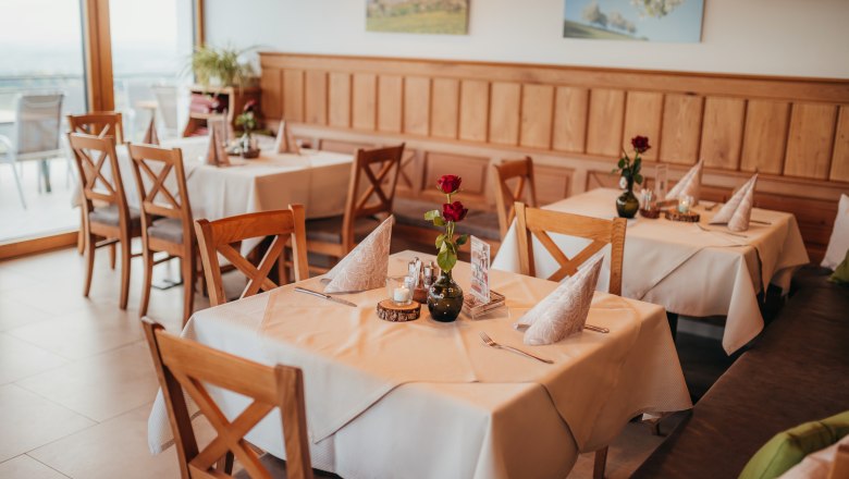 Gemütliches Restaurant mit Holzmöbeln und gedeckten Tischen.