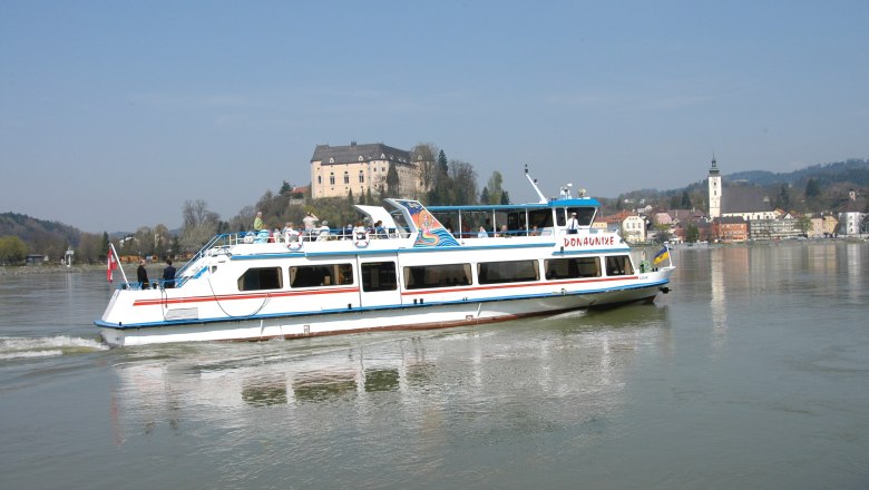 Passagierschiff auf der Donau vor Schloss und Kirchturm im Hintergrund., © Donauschiffahrt Ardagger