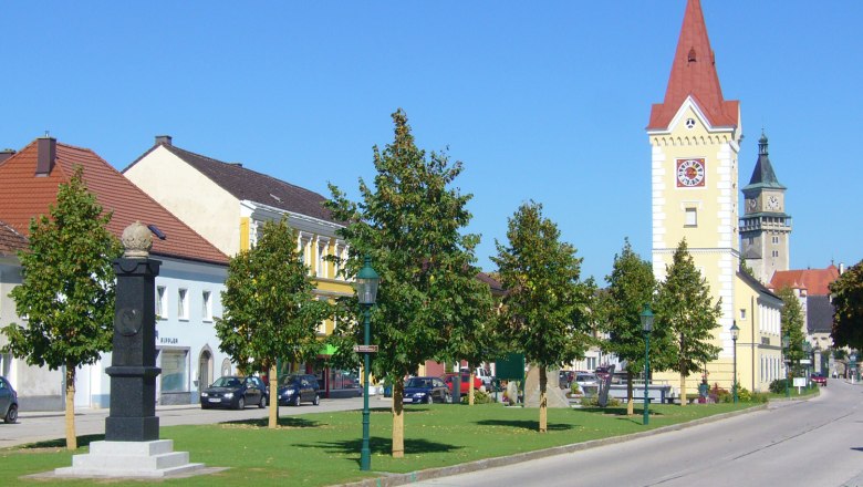 Stadtzentrum mit Turm und Schloss im Hintergrund.