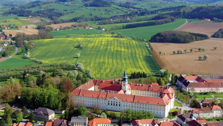 Luftaufnahme des Benediktinerstifts Seitenstetten umgeben von grünen Feldern und Hügeln.